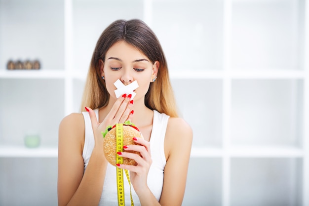 Retrato mujer quiere comer una hamburguesa pero atascado boca skochem