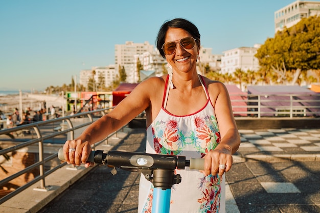 Retrato de mujer en retiro de scooter eléctrico y paseo de verano en un resort de isla tropical para felices vacaciones Calle de la ciudad y transporte ecológico abuela divertida en scooter de vacaciones en Hawai