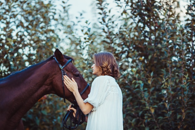 Retrato de mujer romántica con el caballo. Soñando con el mejor amigo