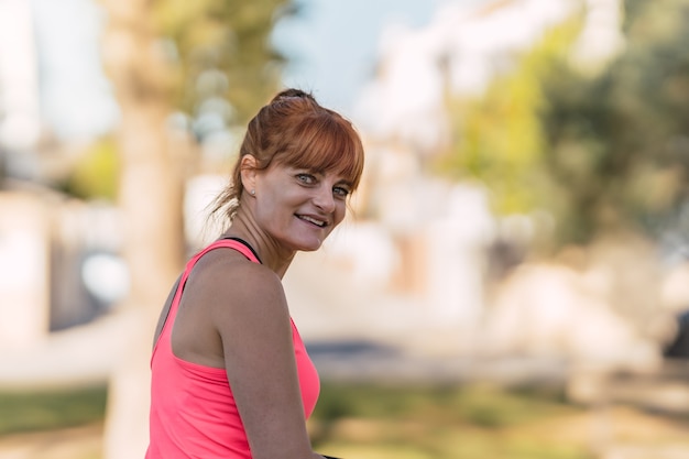 Retrato de una mujer en ropa deportiva en el parque.