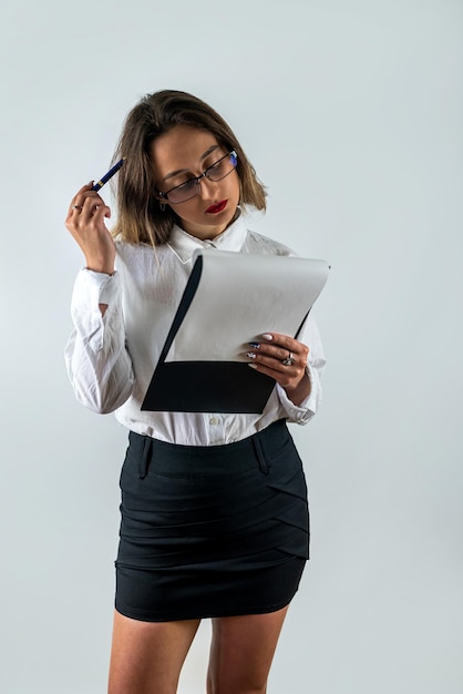 Retrato de mujer en ropa formal sosteniendo portapapeles y sonriendo a la cámara de fondo aislado