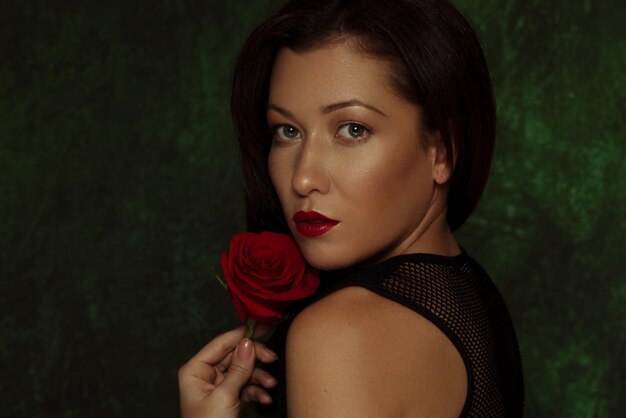 Foto retrato de una mujer con una rosa en casa