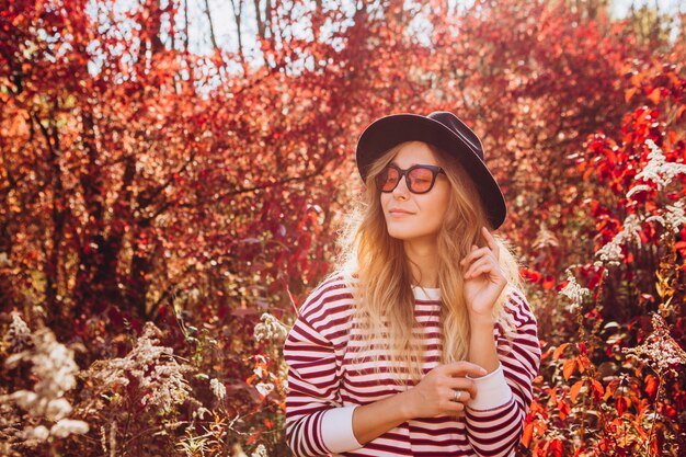 Retrato de una mujer rubia en el bosque de otoño