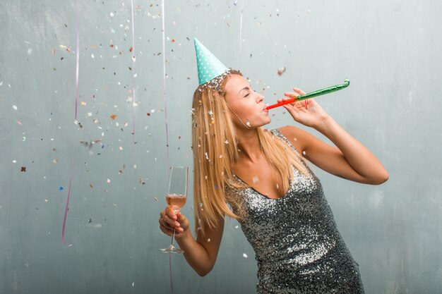 Retrato de la mujer rubia elegante joven que celebra un partido.