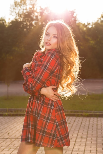 Foto retrato de mujer rubia glamorosa con vestido a cuadros de moda