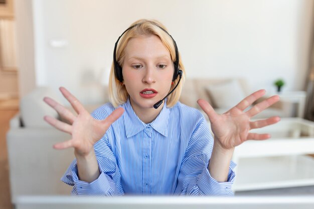 Retrato de una mujer rubia haciendo una llamada de video usando una computadora portátil Una mujer de negocios con auriculares hablando durante una reunión en línea con una compañera Una mujer albino trabajando desde casa en una videoconferencia en la computadora
