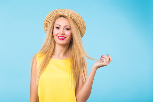 Retrato de mujer rubia hermosa joven sonriente alegre feliz en la pared azul.