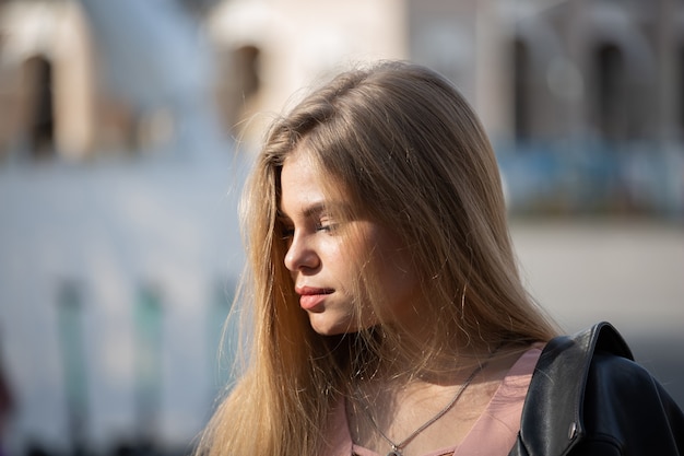 Retrato de mujer rubia joven feliz en gafas de sol con pelo largo