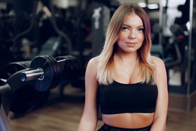 Retrato de una mujer rubia joven en forma en sujetador deportivo negro