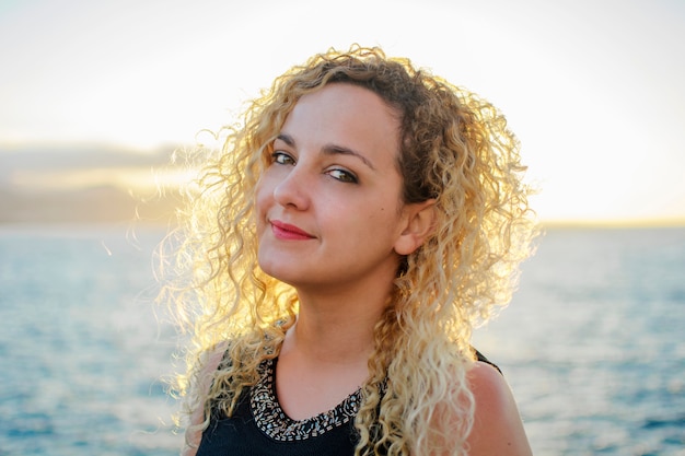 Retrato de mujer rubia con el pelo rizado iluminado por el sol.