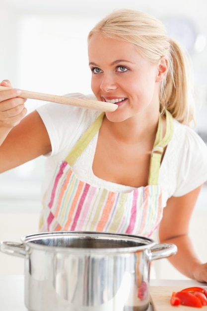 Retrato de una mujer rubia que prueba su comida