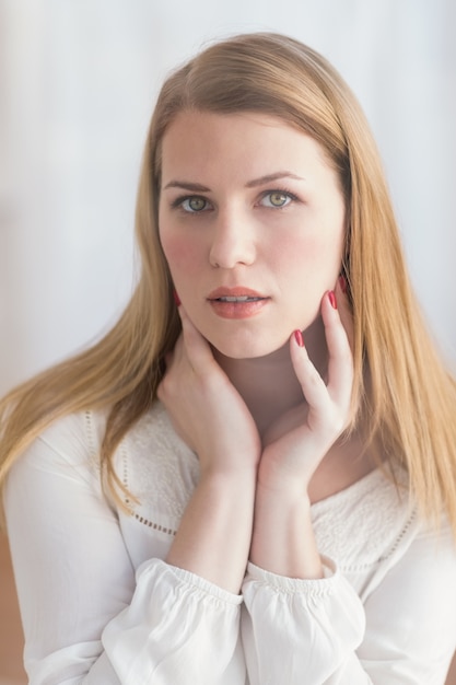 Retrato de una mujer rubia seria mirando la cámara