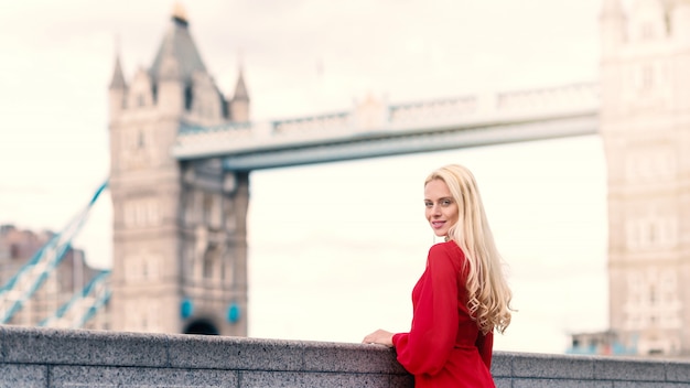 Retrato de mujer rubia sonriente en Londres con el Tower Bridge