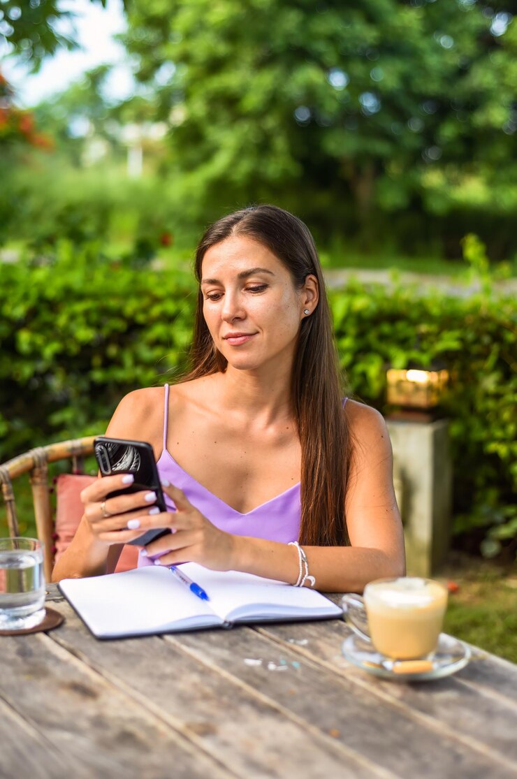 Foto retrato de una mujer rusa sentada y desplazando el teléfono con una taza de café