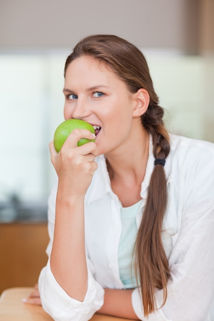 Retrato de una mujer sana comiendo una manzana