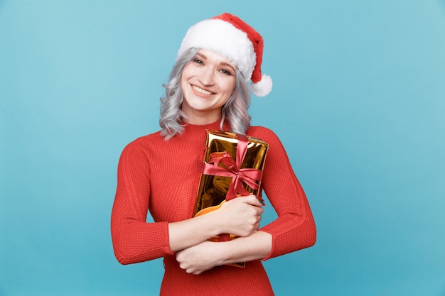 Retrato de mujer santa feliz abraza caja de regalo aislada