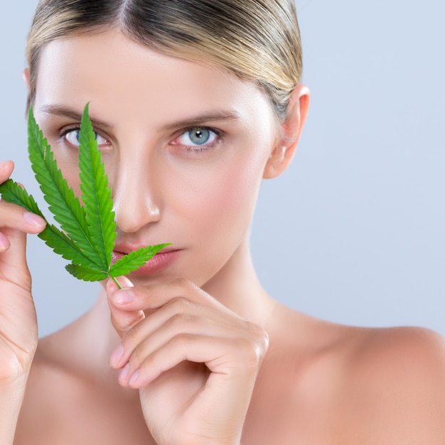 Retrato de mujer seductora de primer plano con hoja verde como concepto de belleza de cannabis