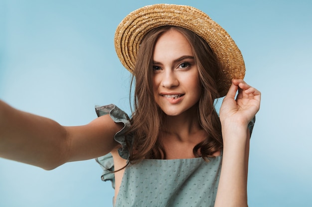 Retrato de una mujer seductora en vestido y sombrero de verano