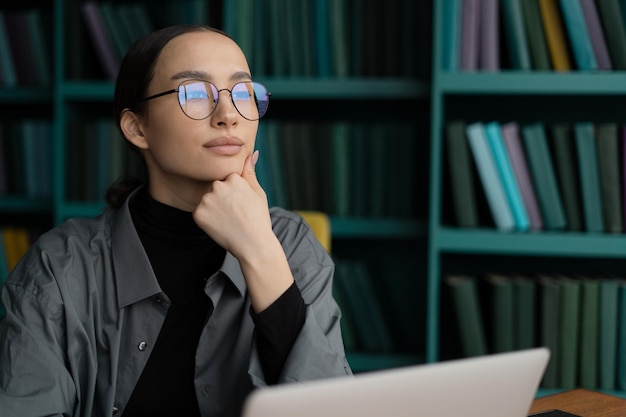 Retrato de una mujer segura de sí misma con anteojos, una abogada que trabaja en una oficina usando una computadora portátil Concepto de oficina