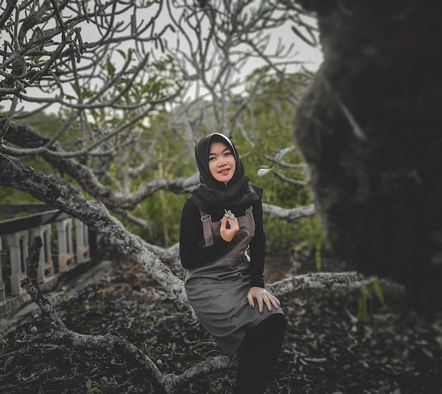 Foto retrato de una mujer sentada en el árbol