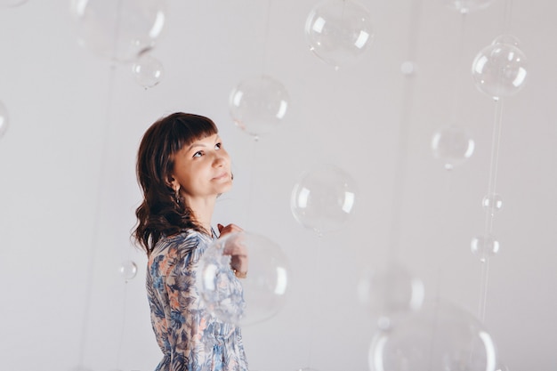 Retrato de mujer sobre un fondo blanco con bolas de cristal