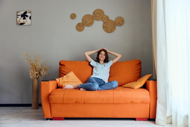Foto retrato de una mujer en el sofá naranja en el baño posando apartamentos foto de alta calidad