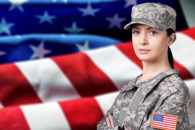 Retrato de mujer soldado del ejército estadounidense en el fondo de la bandera