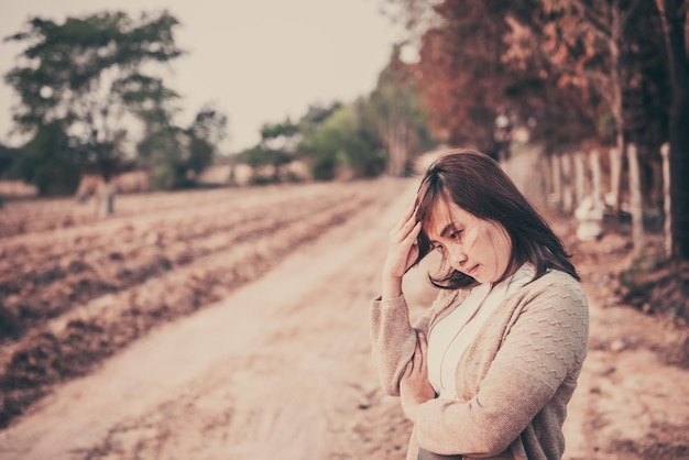 Retrato de una mujer solitaria sola en un campo. Estilo de filtro vintage. La angustia del concepto de chica lovesad en el estilo vintage de la puesta de sol.