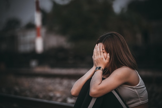 Retrato de una mujer solitaria sola en el estilo de filtro de la vendimia del ferrocarril. La angustia del concepto de chica lovesad en el estilo vintage de la puesta del sol.