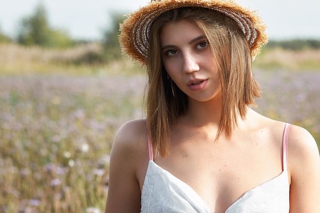 Retrato de una mujer con un sombrero en un campo de flores