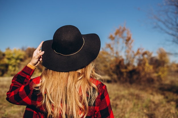 Retrato de una mujer con un sombrero negro en el campo