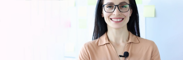 Retrato, de, mujer sonriente, en, anteojos, con, micrófono, en, blusa