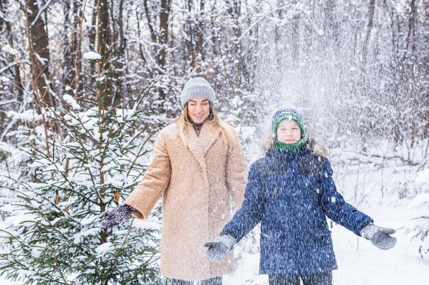 Retrato de una mujer sonriente con un árbol cubierto de nieve durante el invierno