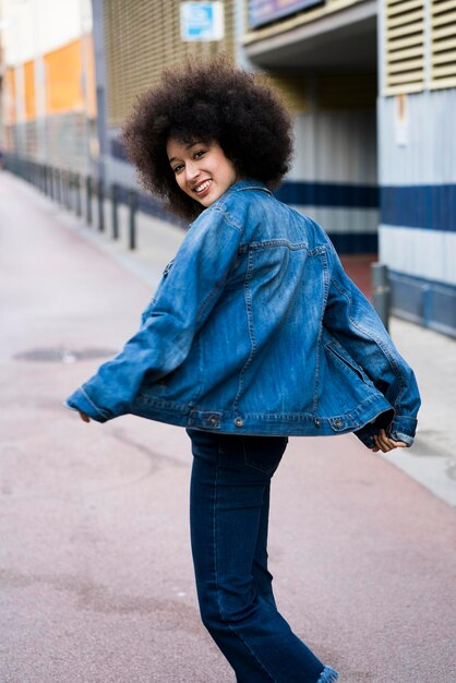 Retrato de mujer sonriente bailando en la calle