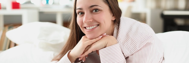 Retrato de mujer sonriente en una cama blanca