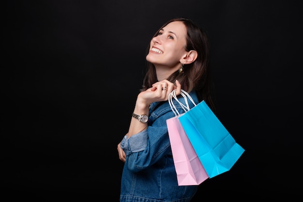 Retrato de mujer sonriente en casual con coloridos bolsos de compras