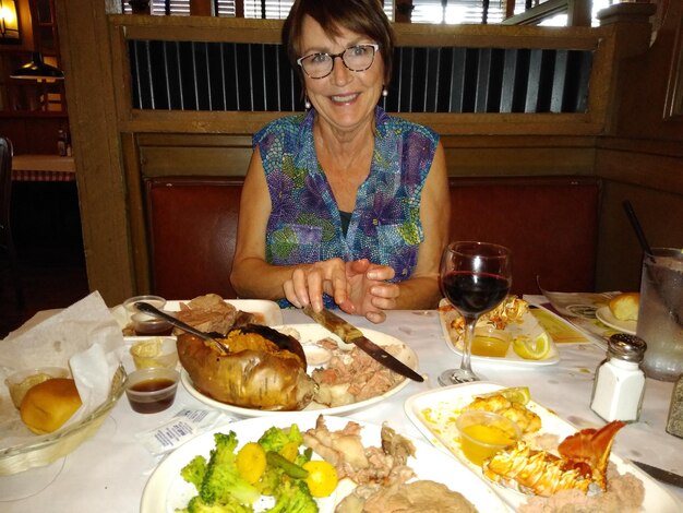 Foto retrato de una mujer sonriente comiendo en un restaurante