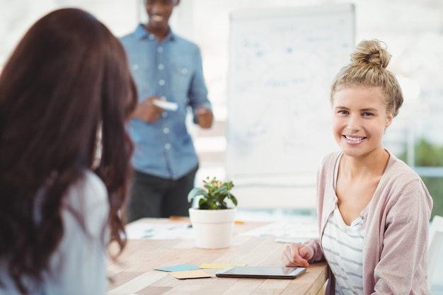 Retrato de mujer sonriente con compañero de trabajo