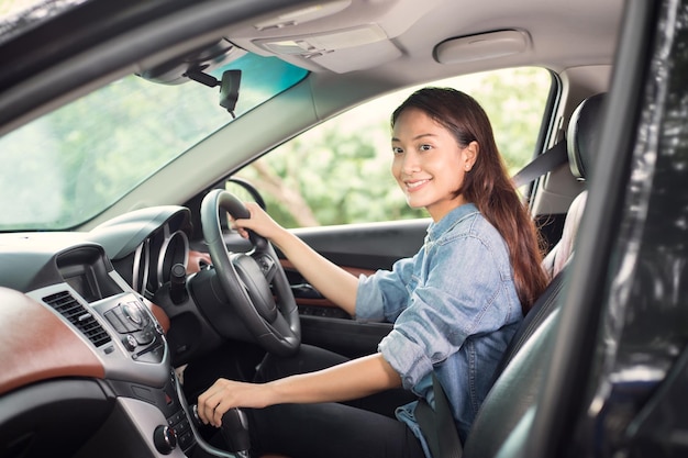 Retrato de una mujer sonriente conduciendo un coche