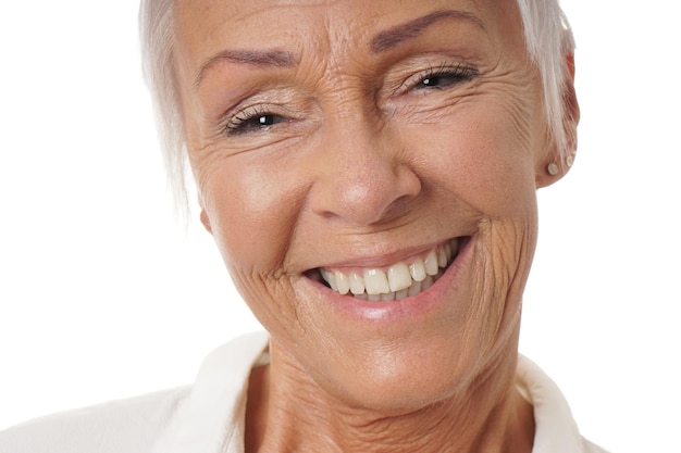 Foto retrato de una mujer sonriente contra un fondo blanco