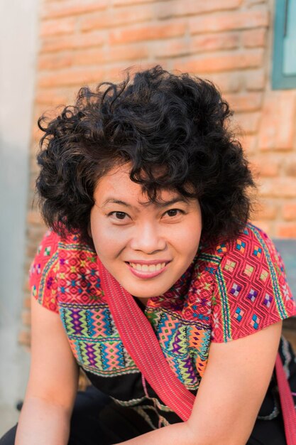 Foto retrato de una mujer sonriente contra la pared