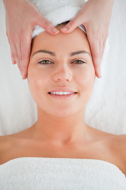 Retrato de una mujer sonriente disfrutando de un masaje facial