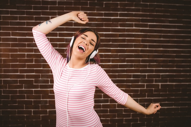 Foto retrato de mujer sonriente escuchando música con auriculares