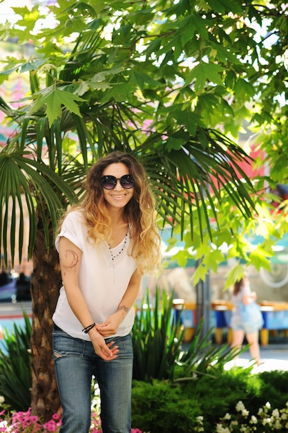 Retrato de mujer sonriente feliz, al aire libre cerca de una palmera