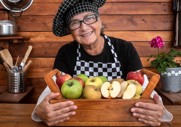 Retrato de una mujer sonriente con frutas en casa