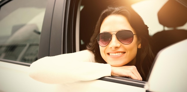 Retrato de mujer sonriente con gafas de sol en su coche