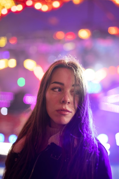 Retrato de una mujer sonriente con luces iluminadas por la noche