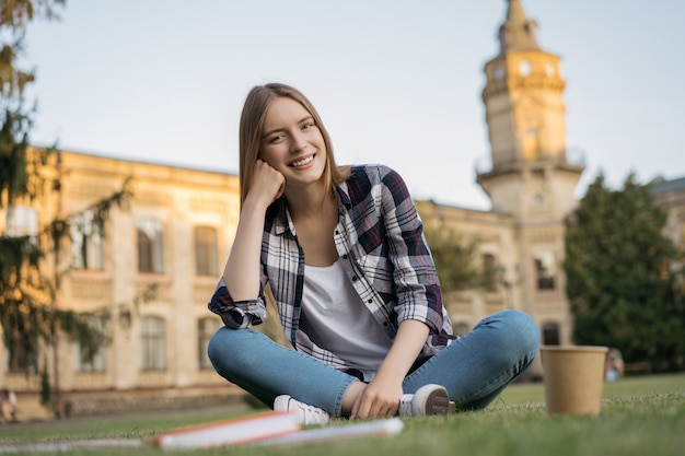 Retrato de mujer sonriente mirando a cámara, sentado en el parque