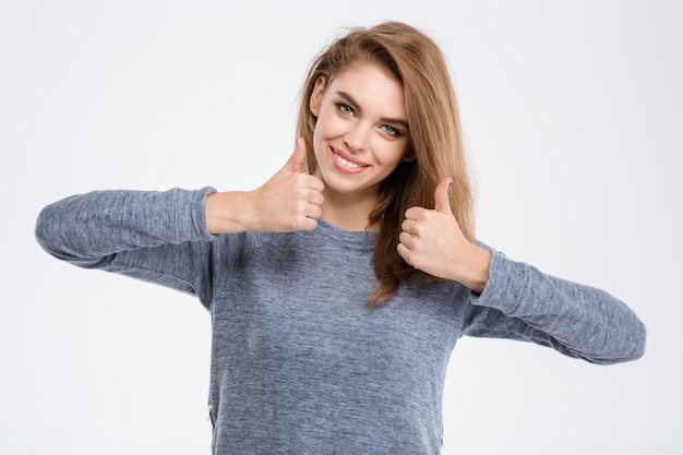 Retrato de una mujer sonriente mostrando Thumbs up aislado sobre un fondo blanco.