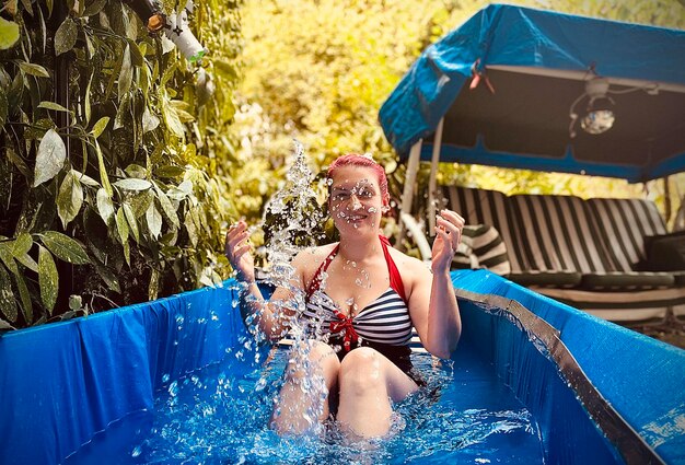 Retrato de una mujer sonriente nadando en la piscina